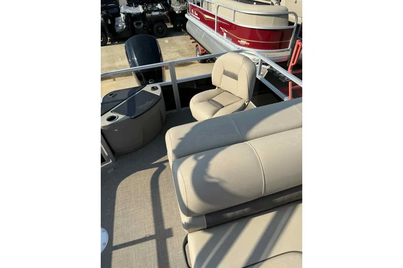 Slide: The Image of 2023 Sun Tracker SportFish 20 DLX pontoon boat interior with beige seating and helm. - 6