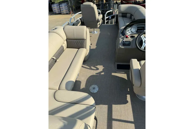 Slide: The Image of 2023 Sun Tracker SportFish 20 DLX pontoon boat interior with beige seating and steering console. - 7