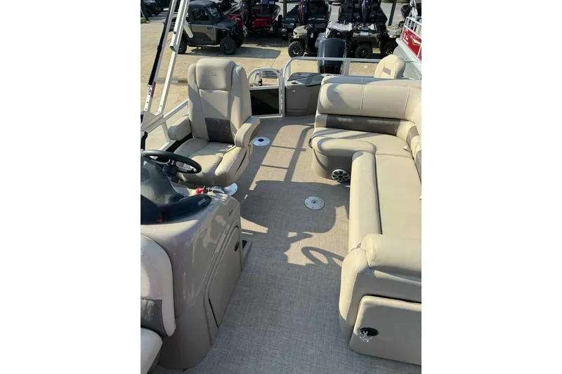 Slide: The Image of 2023 Sun Tracker SportFish 20 DLX pontoon boat interior with beige seating and steering console. - 9