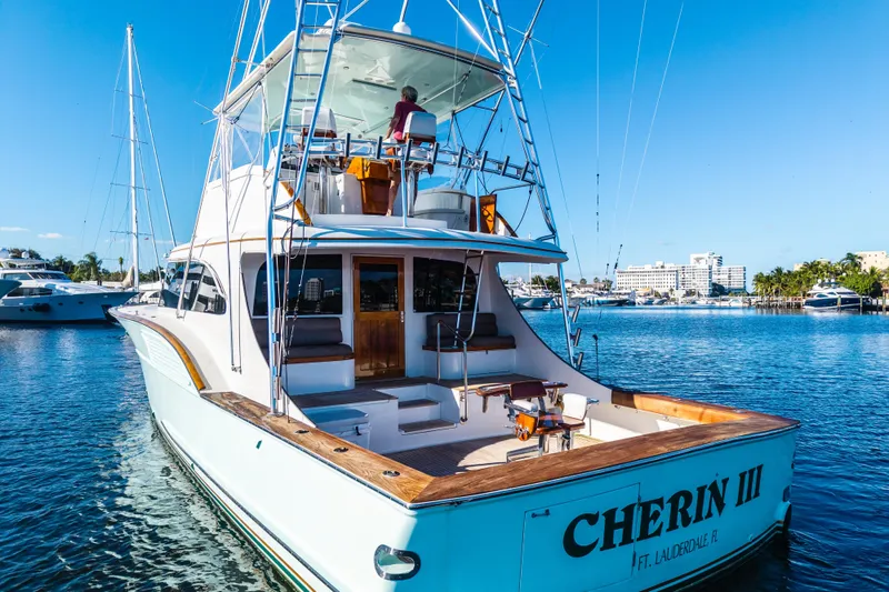 Slide: The Image of 2004 B&D 65 Flybridge yacht on water, sunny day, marina background. - 2