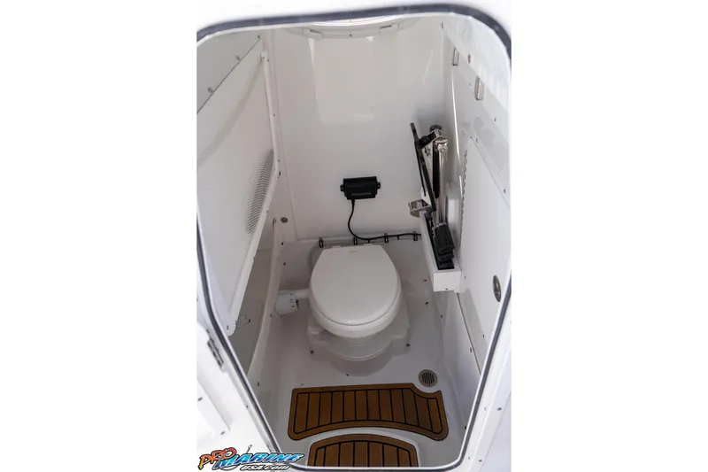 Slide: The Image of 2026 Sea Hunt Ultra 275 SE boat interior with compact marine toilet and wooden floor accents. - 37