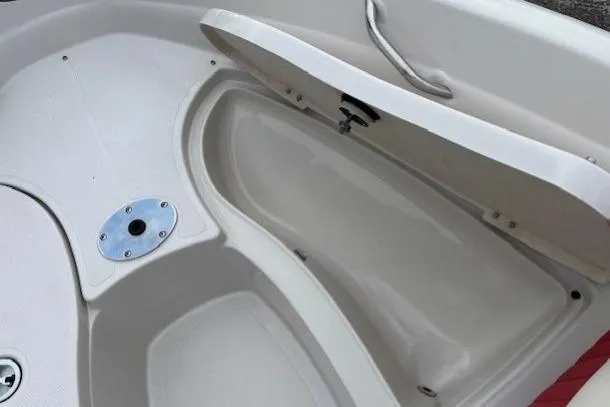 Slide: The Image of 2008 Tahoe Q5i SF boat storage compartment with open lid and clean interior. - 11