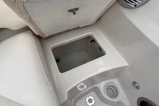 Slide: The Image of 2008 Tahoe Q5i SF boat storage compartment with open lid and cup holders. - 25