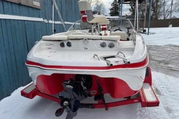 Slide: The Image of 2008 Tahoe Q5i SF boat on trailer, red and white design, parked on snowy ground. - 5