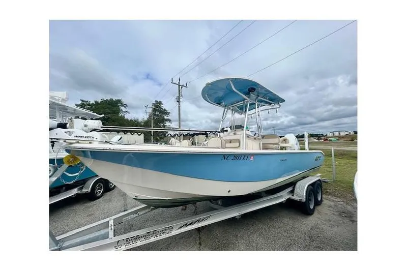 The Image of 2021 Carolina Skiff 24 Ultra Elite boat on trailer, blue and white design, parked outdoors. - 1