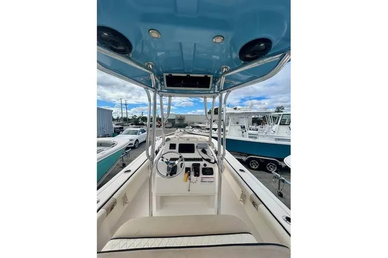 Slide: The Image of 2021 Carolina Skiff 24 Ultra Elite boat interior with steering console and blue canopy. - 10