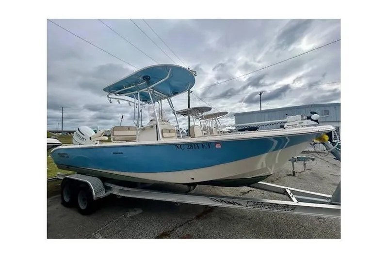 Slide: The Image of 2021 Carolina Skiff 24 Ultra Elite boat on trailer, under cloudy sky. - 11