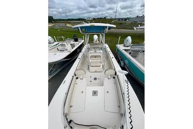 Slide: The Image of 2021 Carolina Skiff 24 Ultra Elite boat, spacious deck, center console, parked outdoors. - 7