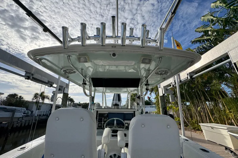 Slide: The Image of 2009 Venture 39 Center Console boat with dual seats and rod holders, docked under a cloudy sky. - 14