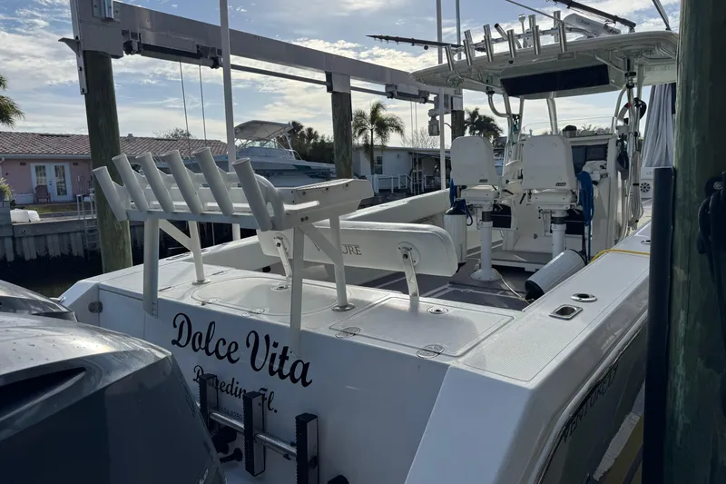 Slide: The Image of 2009 Venture 39 Center Console boat docked, featuring fishing rod holders and dual captain chairs. - 16