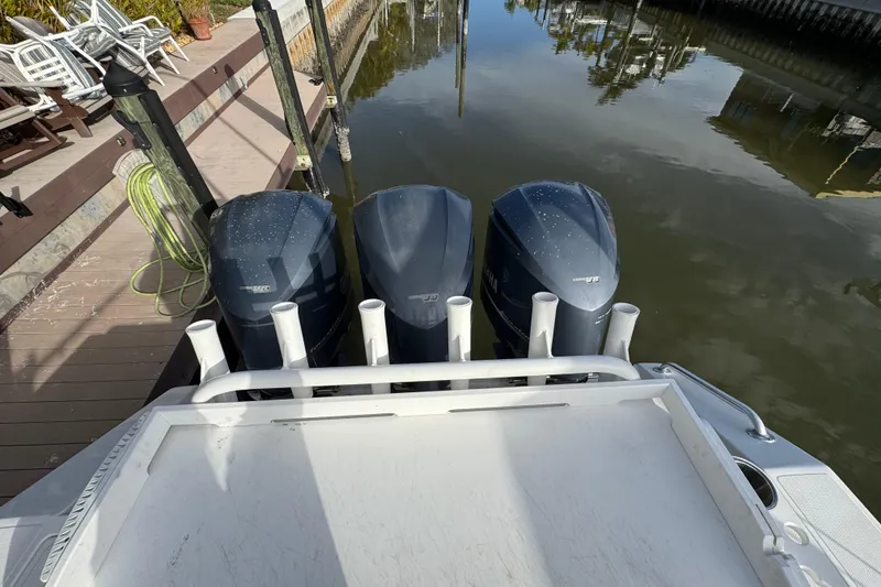Slide: The Image of 2009 Venture 39 Center Console with triple outboard engines docked by a wooden pier. - 4