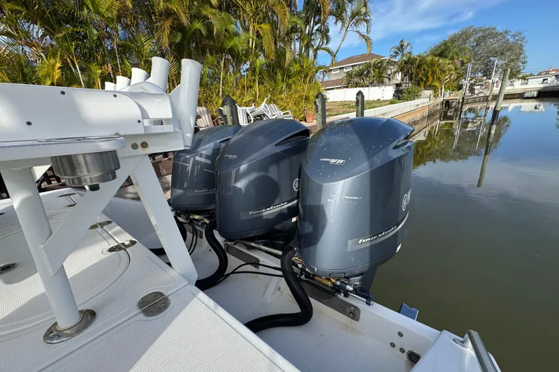 Slide: The Image of 2009 Venture 39 Center Console with triple Yamaha outboard engines docked by palm trees. - 5
