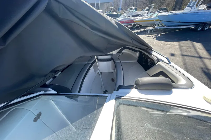Slide: The Image of 2019 Yamaha Boats 242 Limited S E-Series interior with seating and cover partially open. - 7