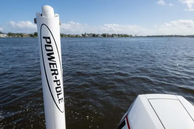 Slide: The Image of 2024 Islamorada Boatworks 24 with Power-Pole on calm water, clear sky background. - 14