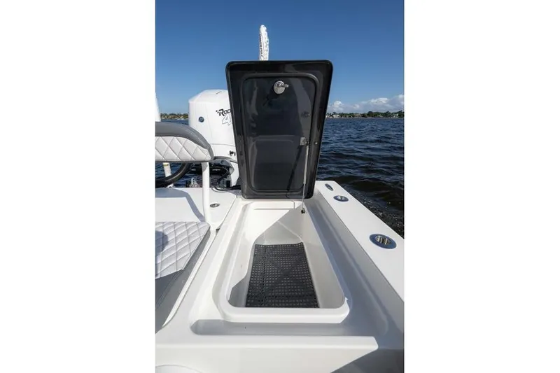 Slide: The Image of 2024 Islamorada Boatworks 24 open storage compartment on a sunny day at sea. - 2