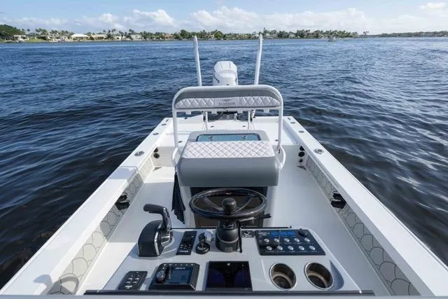Slide: The Image of 2024 Islamorada Boatworks 24, sleek interior, advanced controls, cruising on calm waters. - 21