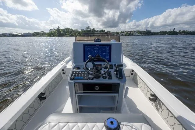 Slide: The Image of 2024 Islamorada Boatworks 24 helm with modern controls on a scenic waterway. - 28