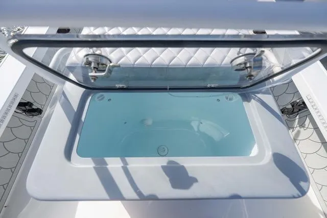 Slide: The Image of 2024 Islamorada Boatworks 24 livewell with open lid, showcasing interior water storage. - 29