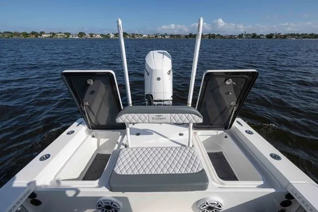 Slide: The Image of 2024 Islamorada Boatworks 24 on water, featuring open storage compartments and cushioned seating. - 3