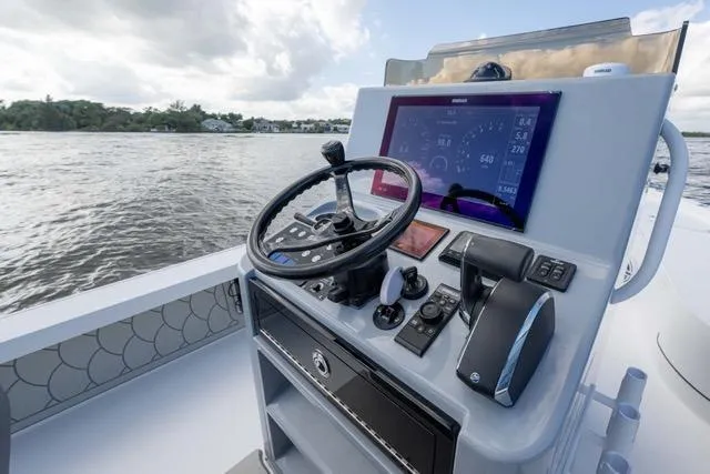 Slide: The Image of 2024 Islamorada Boatworks 24 helm with modern controls and navigation display on the water. - 37
