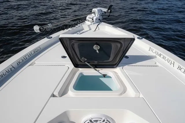 Slide: The Image of 2024 Islamorada Boatworks 24 with open hatch, showcasing sleek design on calm water. - 4