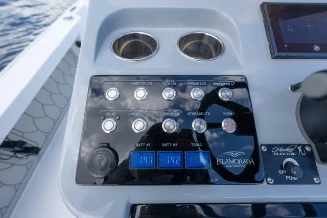 Slide: The Image of Control panel of 2024 Islamorada Boatworks 24, featuring switches and digital displays. - 40