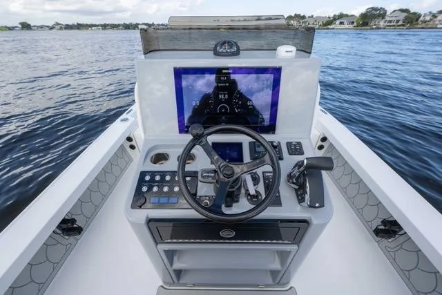 Slide: The Image of 2024 Islamorada Boatworks 24 helm with modern controls and navigation screen on open water. - 41