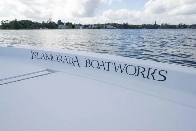 Slide: The Image of 2024 Islamorada Boatworks 24 on calm water, showcasing sleek design and branding. - 49