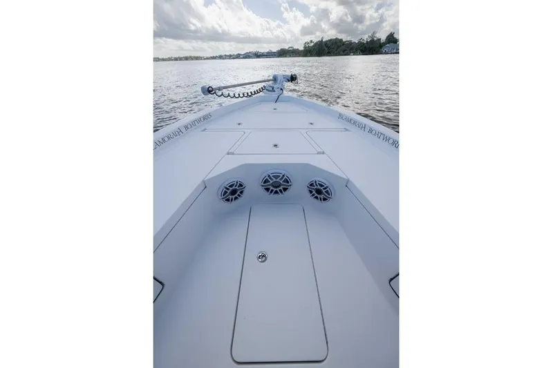 Slide: The Image of 2024 Islamorada Boatworks 24 on calm water, showcasing deck and speakers. - 50