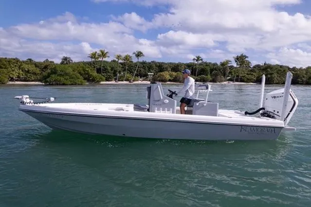 Slide: The Image of 2024 Islamorada Boatworks 24 cruising on clear water near a tropical shoreline. - 61