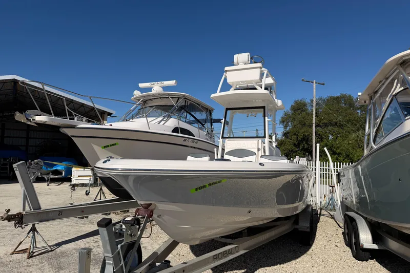 Slide: The Image of 2020 Robalo 246 Cayman SD boat for sale, displayed on a trailer in a marina. - 1