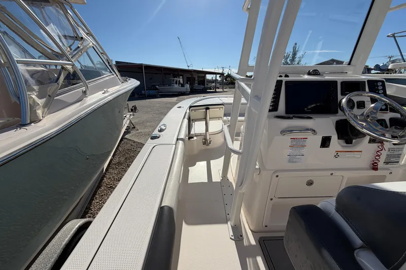 Slide: The Image of 2020 Robalo 246 Cayman SD boat interior with steering console and seating area. - 11