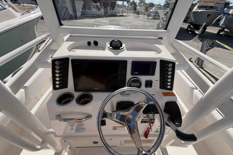 Slide: The Image of 2020 Robalo 246 Cayman SD boat console with steering wheel and navigation controls. - 12