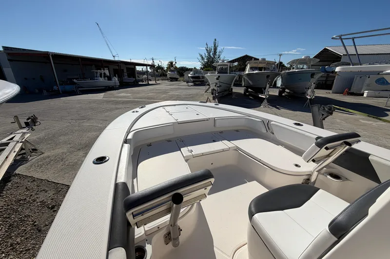 Slide: The Image of 2020 Robalo 246 Cayman SD boat interior at a marina under clear blue sky. - 14