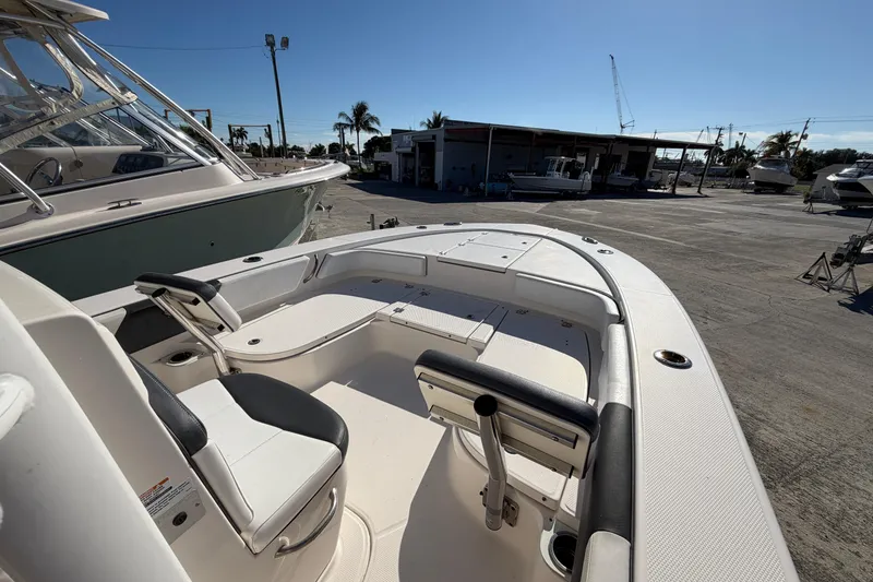 Slide: The Image of 2020 Robalo 246 Cayman SD boat interior with seating and storage, docked under clear sky. - 15