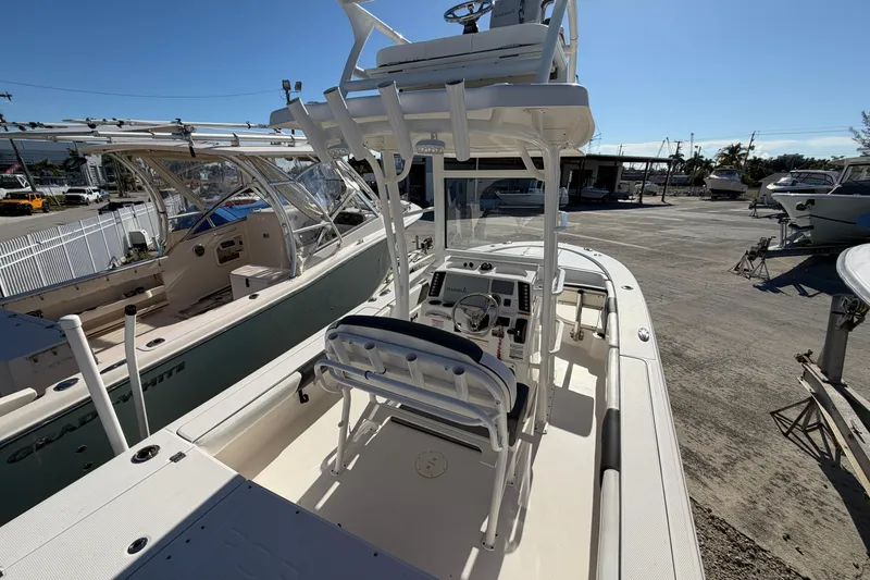 Slide: The Image of 2020 Robalo 246 Cayman SD boat with center console and T-top in a marina setting. - 5