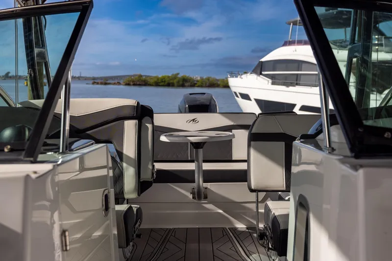 Slide: The Image of 2022 Monterey 275SS Super Sport boat interior with seating and table, docked by the water. - 18