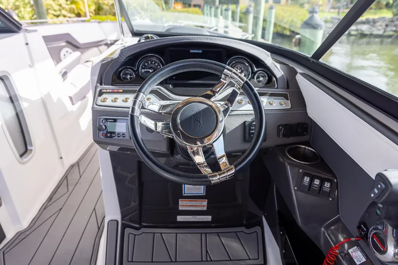 Slide: The Image of 2022 Monterey 275SS Super Sport boat dashboard with modern steering wheel and controls. - 20