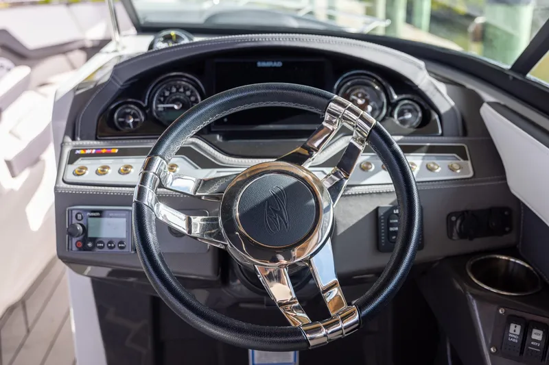 Slide: The Image of 2022 Monterey 275SS Super Sport boat dashboard with steering wheel and controls. - 21