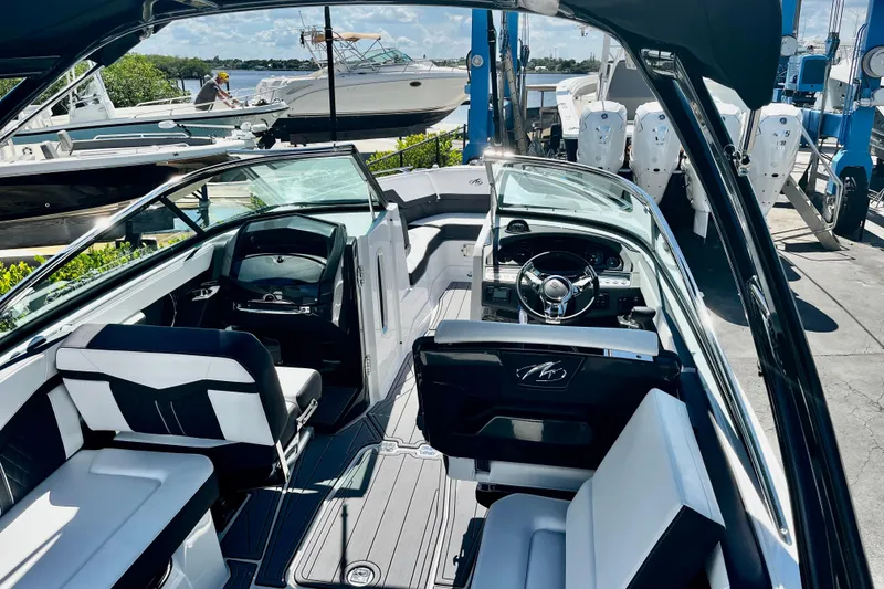 Slide: The Image of 2022 Monterey 275SS Super Sport boat cruising on water with black canopy. - 4