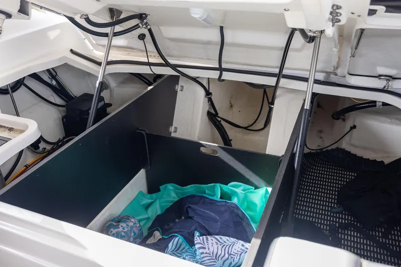 Slide: The Image of Open storage compartment in 2022 Monterey 275SS Super Sport boat with clothes inside. - 43