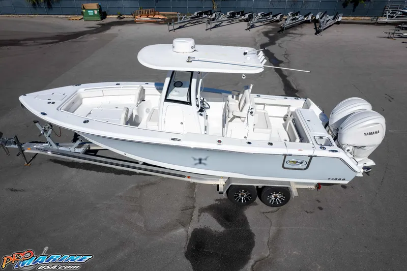 Slide: The Image of 2024 Sea Hunt Gamefish 27 boat on trailer, featuring dual Yamaha engines. - 10