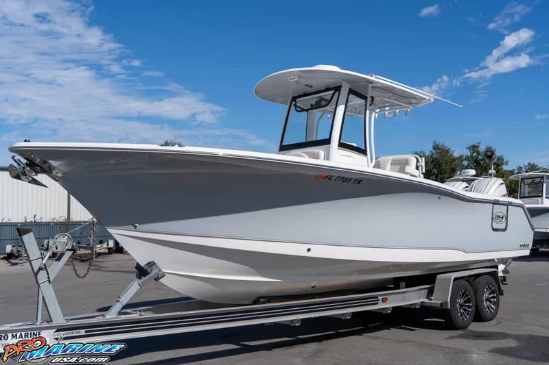 Slide: The Image of 2024 Sea Hunt Gamefish 27 boat on trailer under clear blue sky. - 11