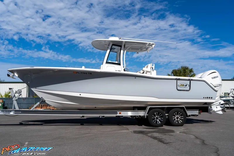 Slide: The Image of 2024 Sea Hunt Gamefish 27 boat on trailer under blue sky. - 13