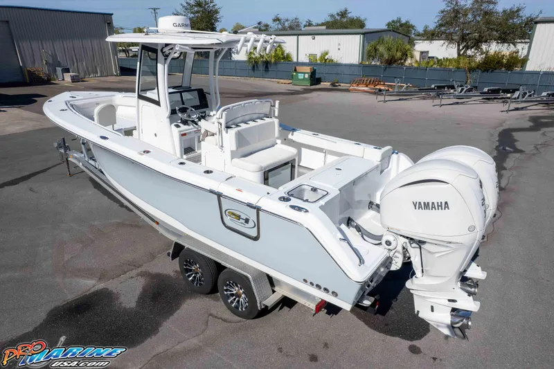 Slide: The Image of 2024 Sea Hunt Gamefish 27 boat with dual Yamaha engines on a trailer. - 14