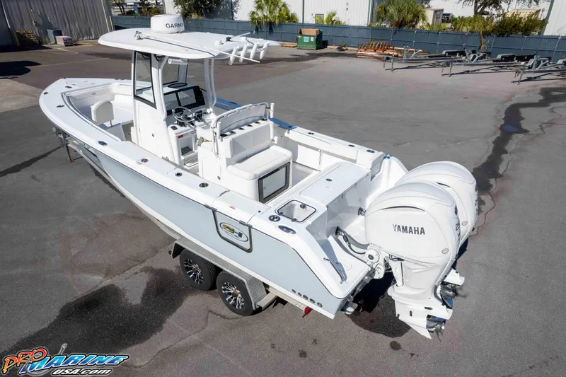 Slide: The Image of 2024 Sea Hunt Gamefish 27 boat with dual Yamaha engines on a trailer. - 16