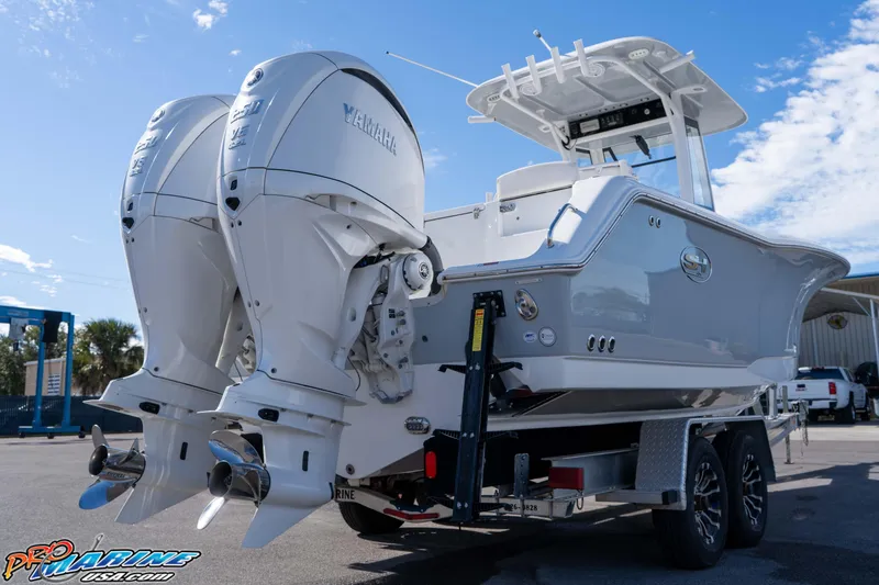 Slide: The Image of 2024 Sea Hunt Gamefish 27 boat with dual Yamaha outboard engines on a trailer. - 23