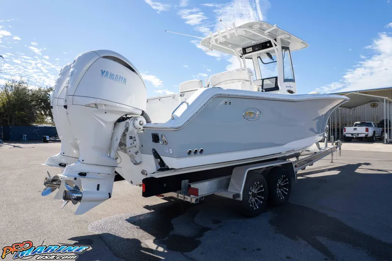 Slide: The Image of 2024 Sea Hunt Gamefish 27 boat on trailer, featuring dual Yamaha outboard engines. - 24