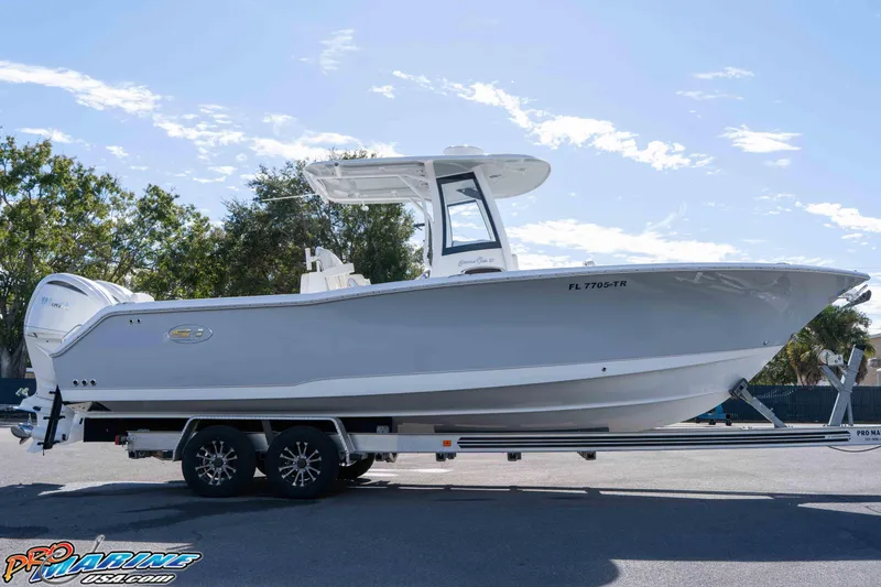 Slide: The Image of 2024 Sea Hunt Gamefish 27 boat on trailer, side view under clear sky. - 25