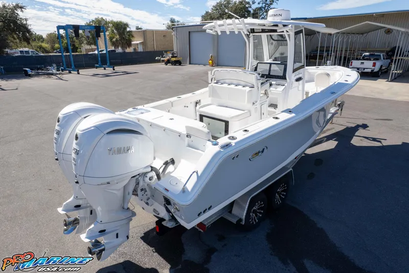 Slide: The Image of 2024 Sea Hunt Gamefish 27 boat with dual Yamaha engines on a trailer. - 26